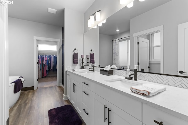 bathroom featuring vanity, hardwood / wood-style flooring, and tasteful backsplash