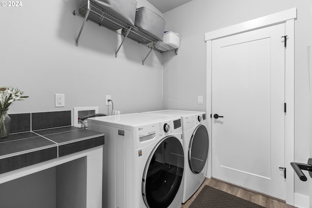 washroom with washing machine and dryer and hardwood / wood-style floors