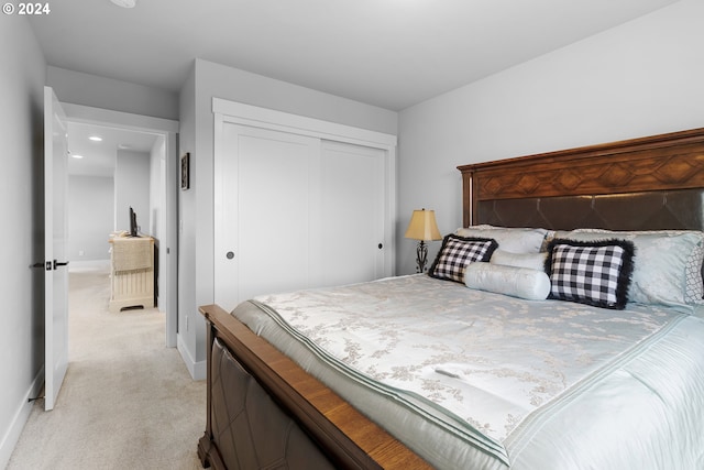 bedroom featuring light carpet and a closet