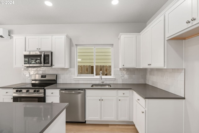 kitchen featuring light hardwood / wood-style flooring, stainless steel appliances, backsplash, white cabinets, and sink