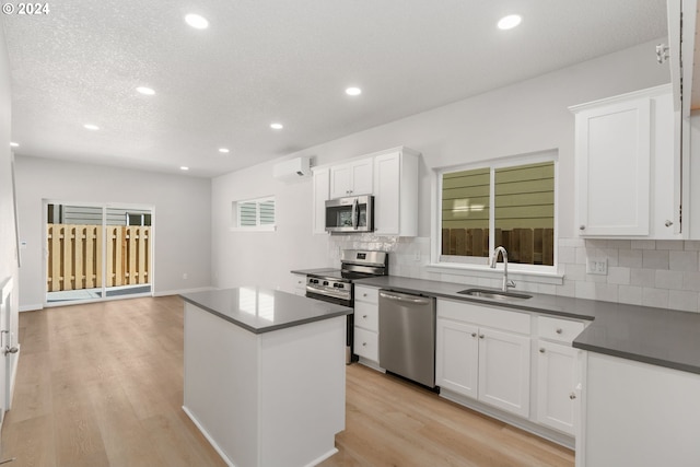 kitchen featuring a center island, stainless steel appliances, backsplash, white cabinets, and sink