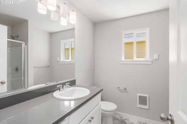 bathroom featuring toilet, an enclosed shower, vanity, and a healthy amount of sunlight