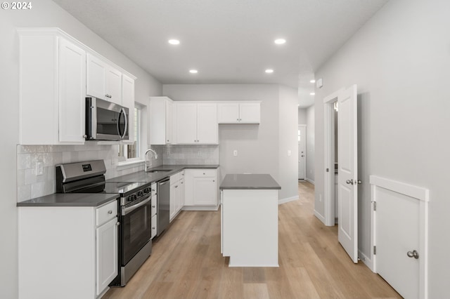 kitchen featuring light hardwood / wood-style flooring, a center island, stainless steel appliances, white cabinets, and sink