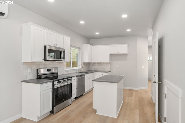 kitchen featuring light hardwood / wood-style floors, stainless steel appliances, white cabinetry, and a kitchen island