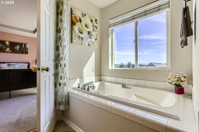 ensuite bathroom with healthy amount of natural light and a bath