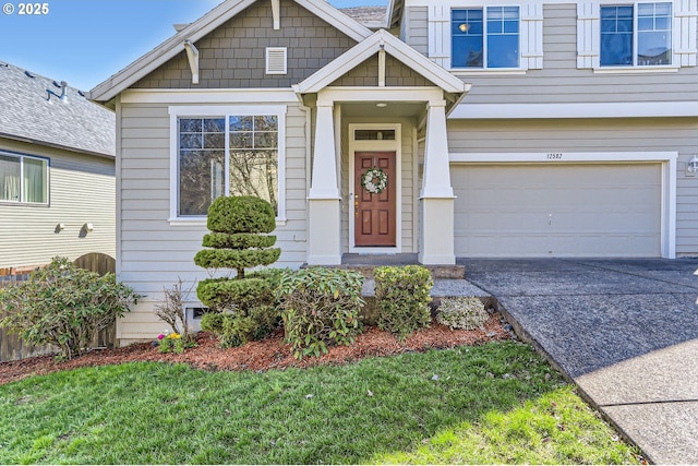 property entrance featuring a garage, concrete driveway, and a lawn