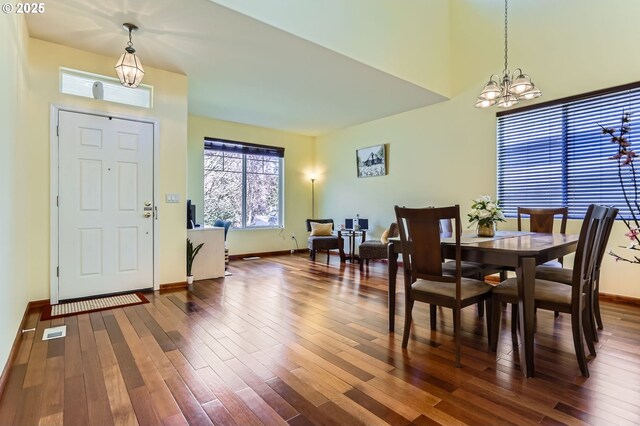 dining space with a chandelier, wood finished floors, and baseboards