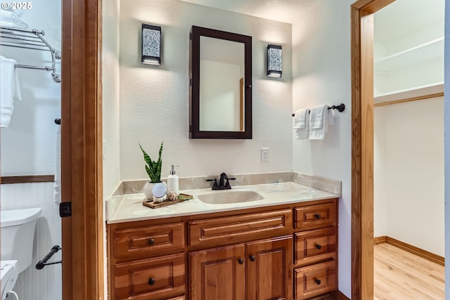 bathroom featuring hardwood / wood-style flooring, vanity, and toilet