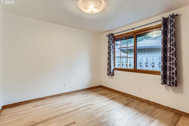 empty room featuring a textured ceiling and wood-type flooring