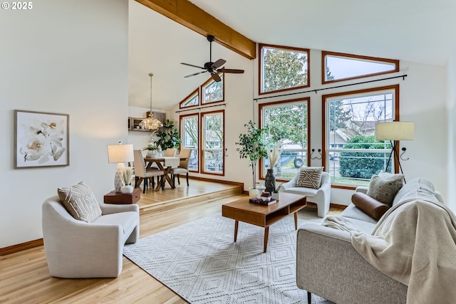 living room with ceiling fan, light wood-type flooring, high vaulted ceiling, and beam ceiling