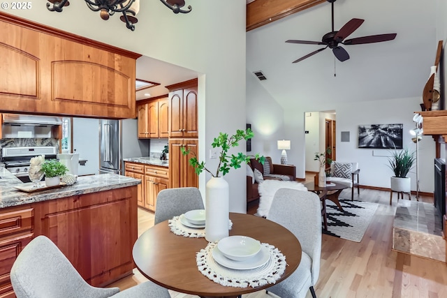 dining space with high vaulted ceiling, light wood-type flooring, and ceiling fan