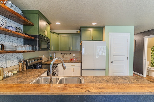 9511 NE 73rd St, Vancouver, WA 98662 - kitchen with green cabinets, freestanding refrigerator, black microwave, a textured ceiling, and recessed lighting