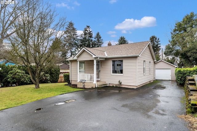 view of front of property with a garage, an outdoor structure, and a front lawn