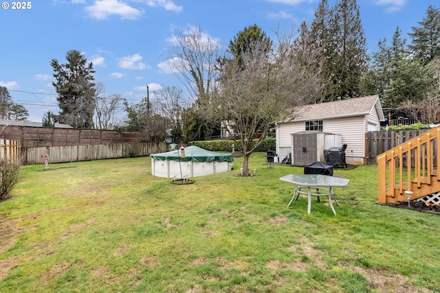 view of yard with a covered pool and a storage unit