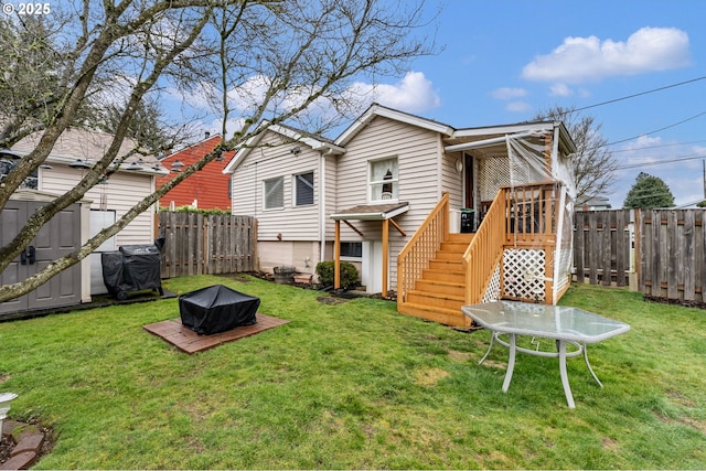 rear view of house with a yard and a fire pit