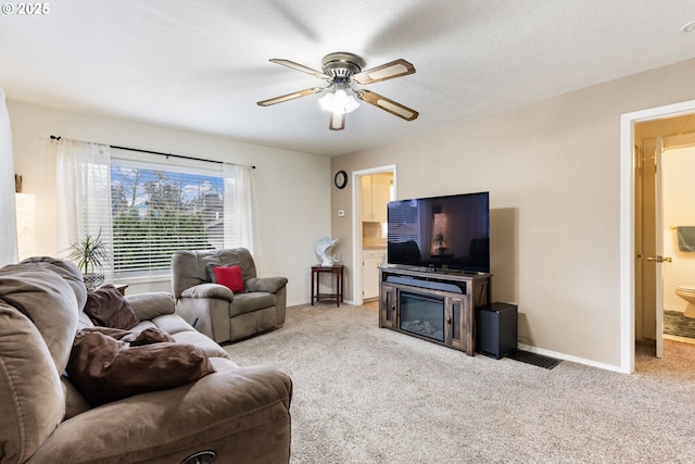 living room featuring light colored carpet, a textured ceiling, and ceiling fan