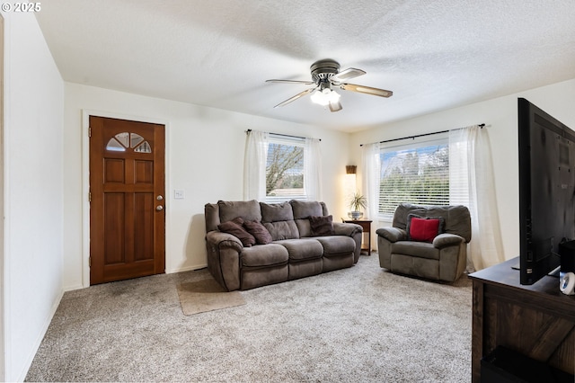 living room featuring ceiling fan, a textured ceiling, and carpet flooring