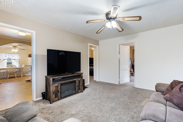 carpeted living room with ceiling fan