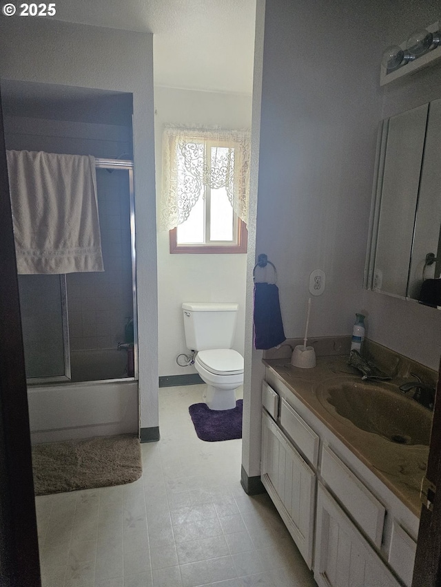 full bathroom featuring tile patterned flooring, vanity, toilet, and combined bath / shower with glass door