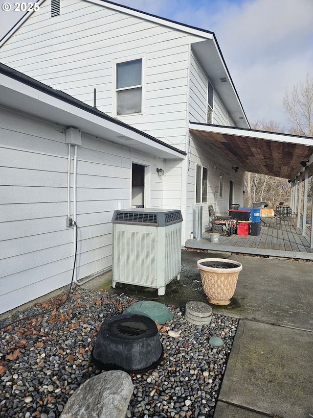 back of property featuring cooling unit and a wooden deck