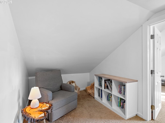 living area with light colored carpet and vaulted ceiling