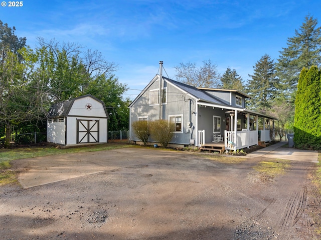 view of front of home with a porch and a shed