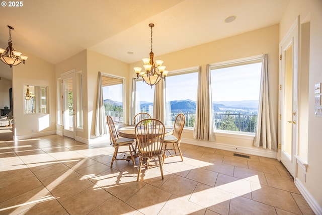 tiled dining area featuring lofted ceiling, a mountain view, and a chandelier