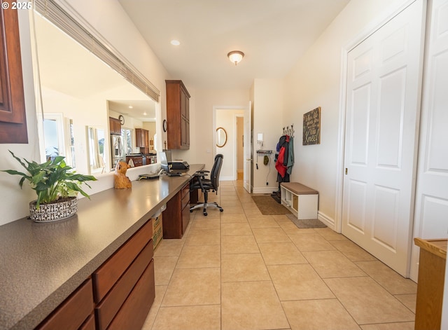 interior space with light tile patterned floors and built in desk