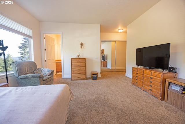 bedroom featuring light carpet and ensuite bathroom