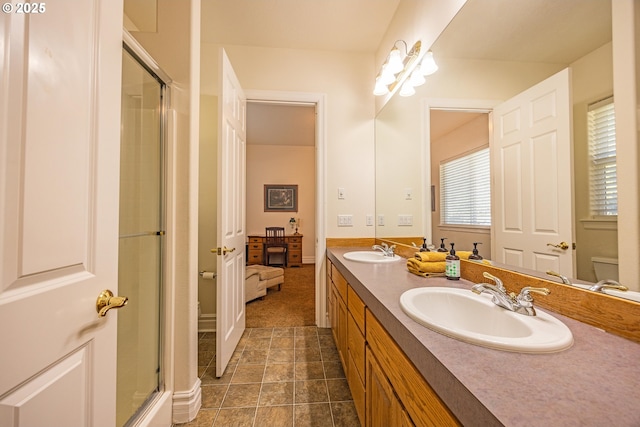 bathroom featuring vanity, toilet, and a shower with door