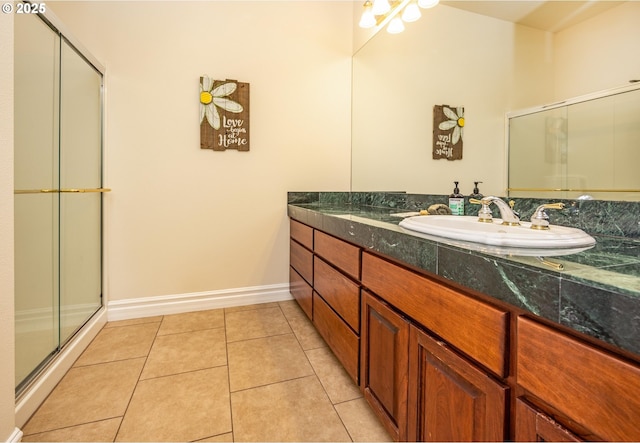 bathroom with a shower with door, vanity, and tile patterned floors