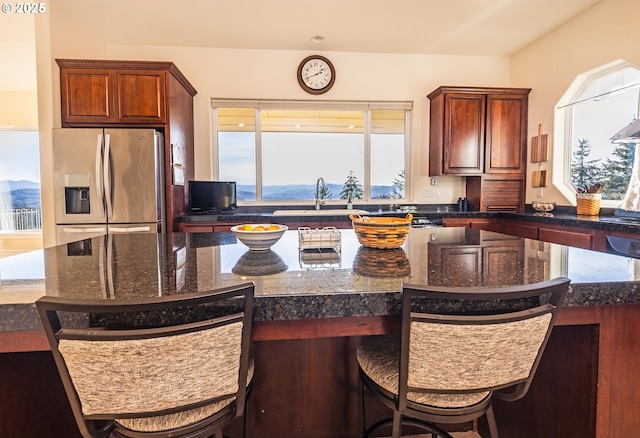 kitchen with a center island, sink, a kitchen bar, and stainless steel fridge with ice dispenser