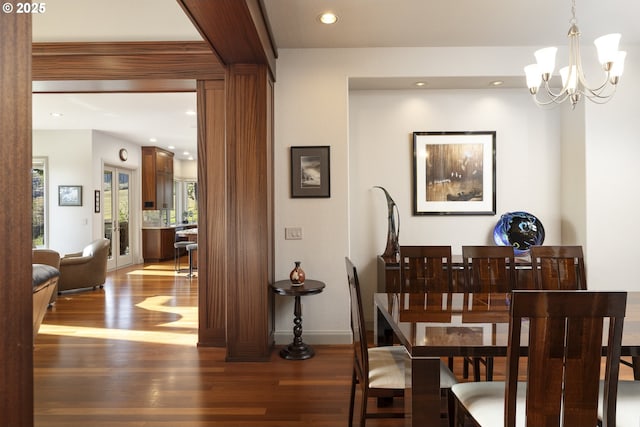 dining area with wood-type flooring and a chandelier