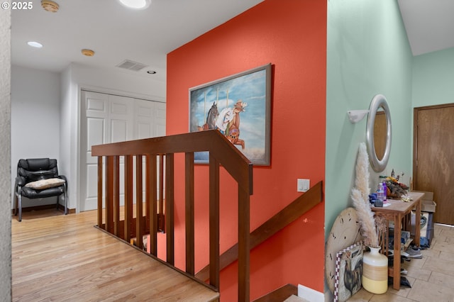 stairway featuring visible vents, recessed lighting, and wood finished floors