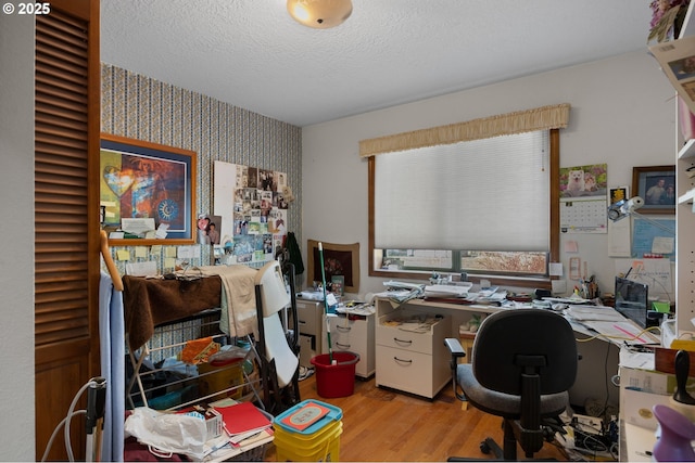 office space featuring a textured ceiling, wood finished floors, and wallpapered walls