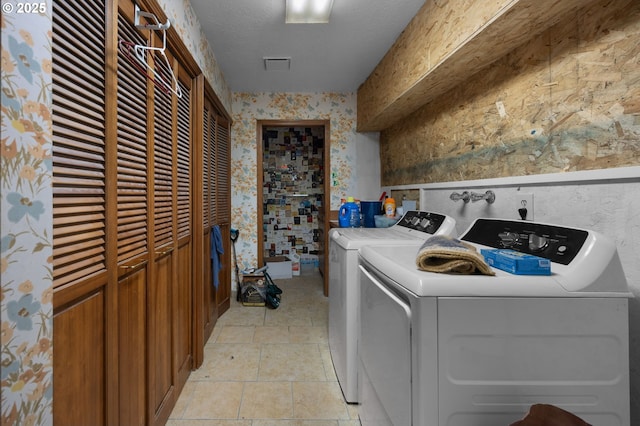 laundry room with visible vents, wallpapered walls, laundry area, a textured ceiling, and independent washer and dryer