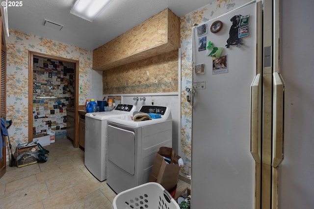 laundry area with washer and clothes dryer, laundry area, wallpapered walls, and visible vents