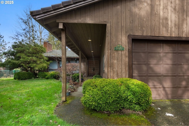 exterior space with a garage, a yard, and a chimney