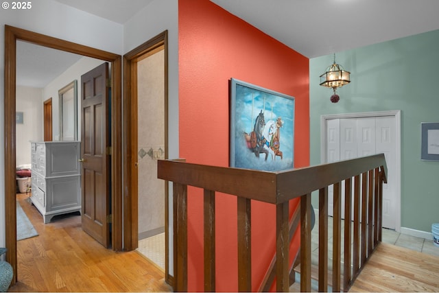 interior space featuring light wood finished floors, an upstairs landing, an inviting chandelier, and baseboards