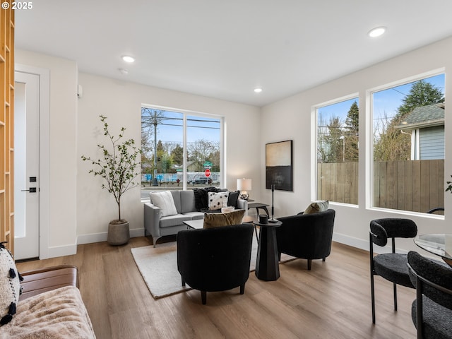 living area featuring recessed lighting, baseboards, and light wood finished floors