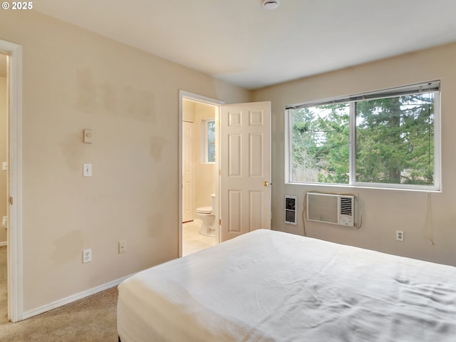 carpeted bedroom with an AC wall unit and ensuite bathroom