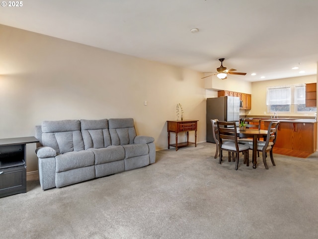 carpeted living room featuring sink and ceiling fan