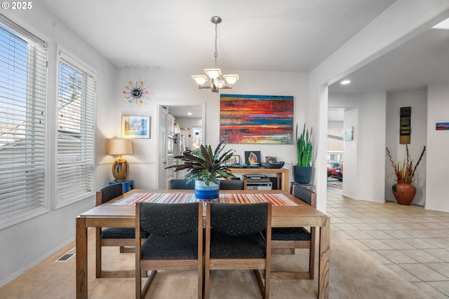 tiled dining area featuring a chandelier