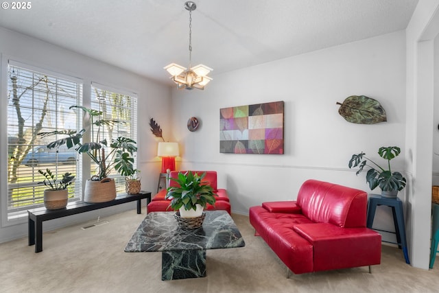 sitting room with carpet and an inviting chandelier