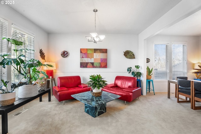 living room with plenty of natural light, carpet, and a notable chandelier