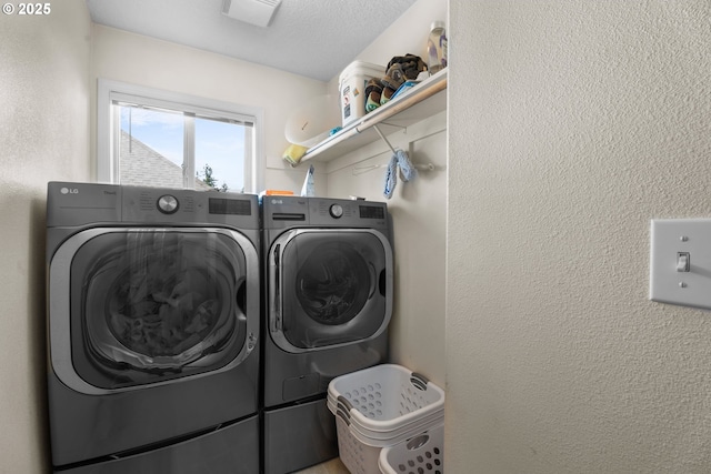 laundry room featuring a textured ceiling and separate washer and dryer