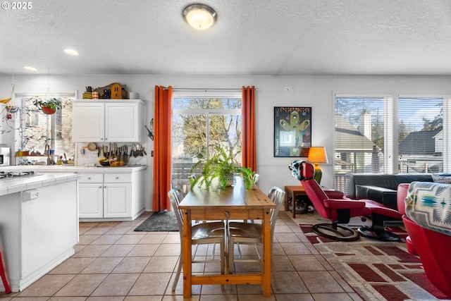 tiled dining room with a textured ceiling