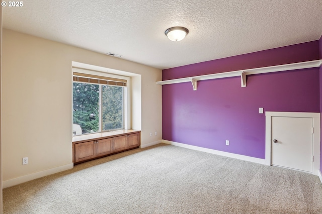 spare room with visible vents, light carpet, and baseboards