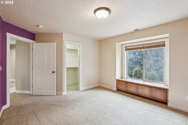 spare room with visible vents, light carpet, baseboards, and a textured ceiling