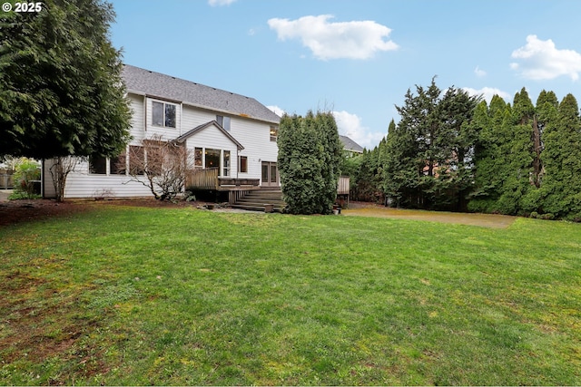 rear view of house with a lawn and a wooden deck